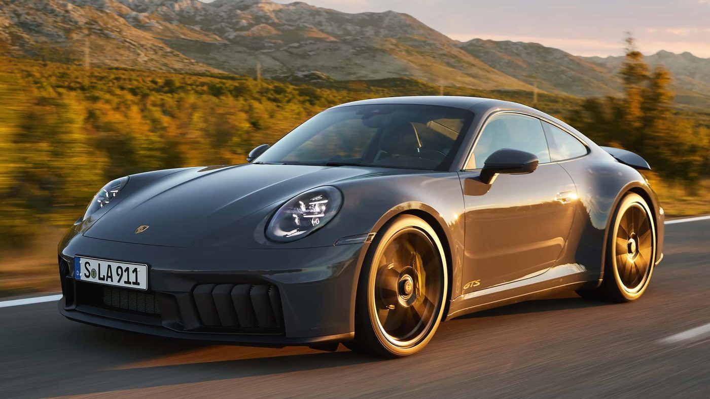 Porsche 911 GTS on a mountain road at golden hour